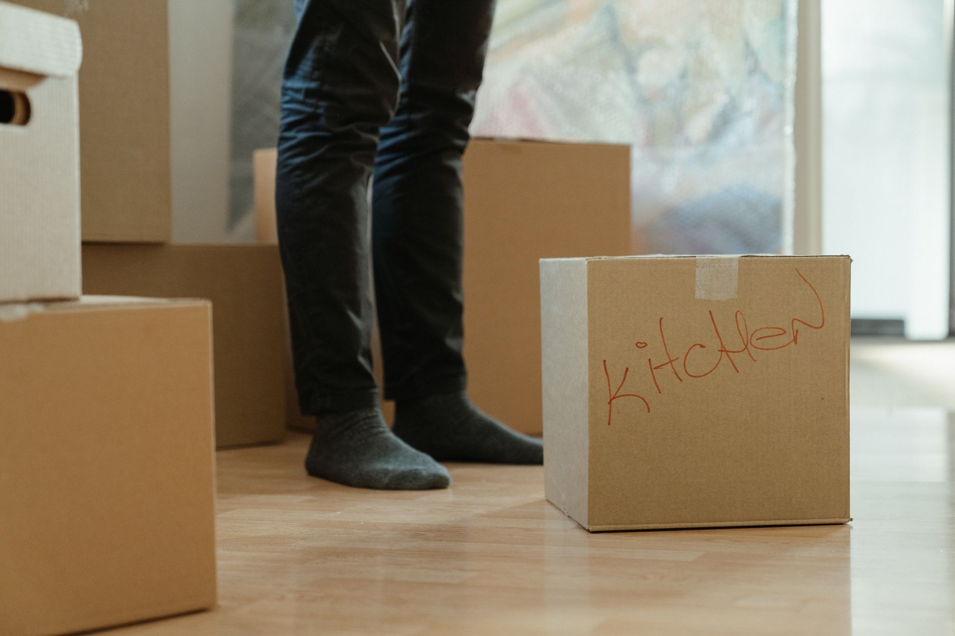 Taşıma kutuları ve paketlenmiş eşyalarla dolu bir evde nakliyat çalışanları